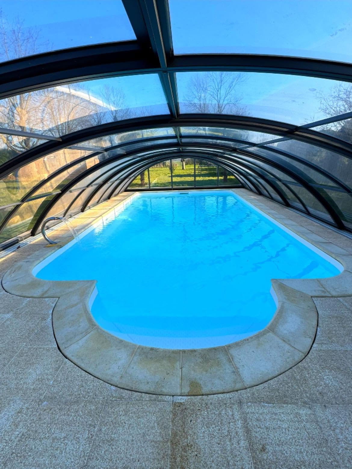 Abri de piscine courbé au profil bas, réalisation Alf Piscine